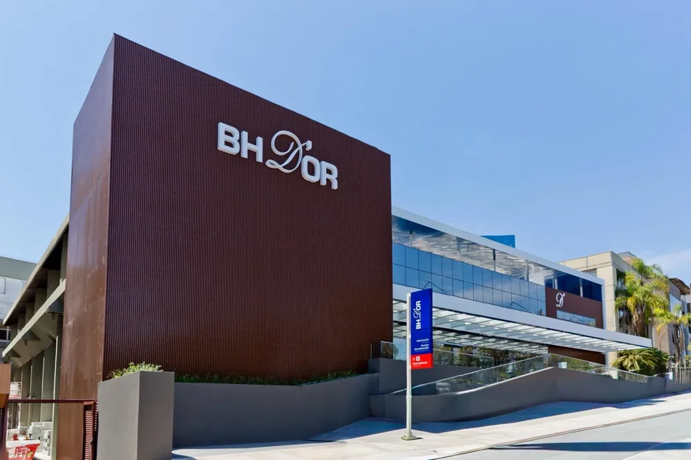 Fachada do Hospital BHD'Or em Nova Lima, com o letreiro sobre o volume revestido em ripas